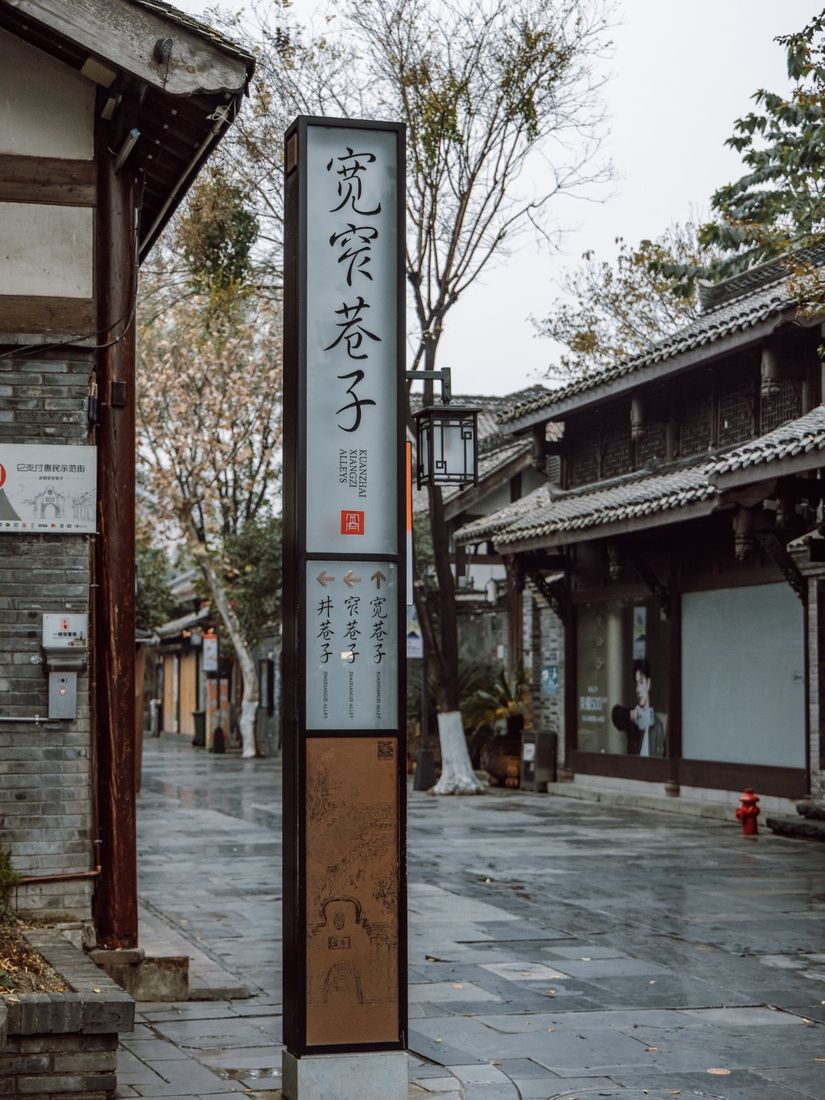 Street sign marking Kuanzhai Alley in Chengdu, with traditional buildings along a stone-paved lane